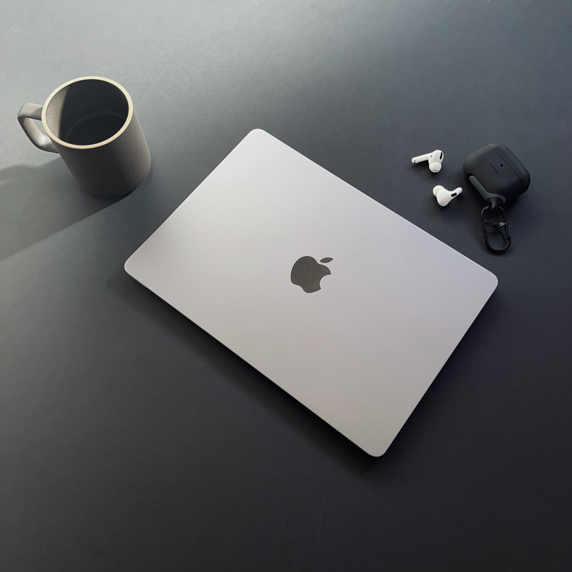 MacBookとマグカップとイヤホン